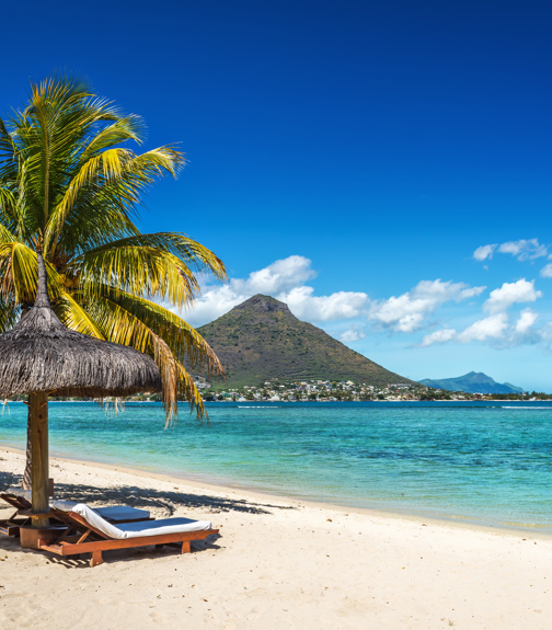 Loungers and umbrella on tropical beach in Mauritius